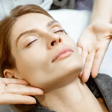 A woman getting a lymphatic drainage massage on face